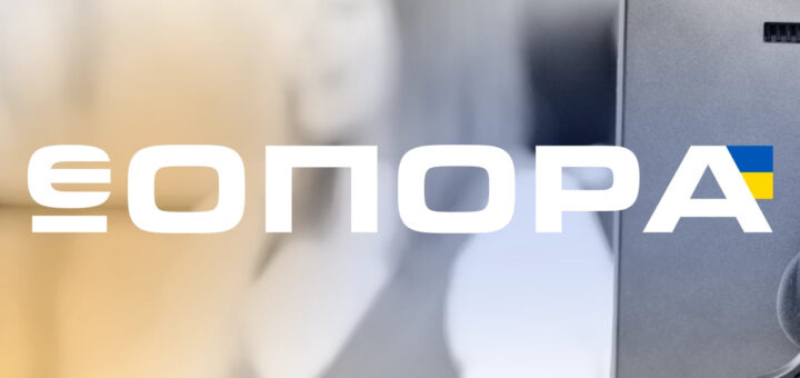 Навушники висять на моніторі комп’ютера, на зображенні білими літерами написано «ЄОПОРА», остання літера «А» має елемент українського прапора