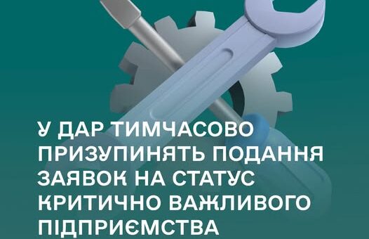 Плакат із зображенням інструментів (гайковий ключ, викрутка, шестерня) на бірюзовому фоні та текстом про тимчасове призупинення подання заявок на статус критично важливого підприємства.