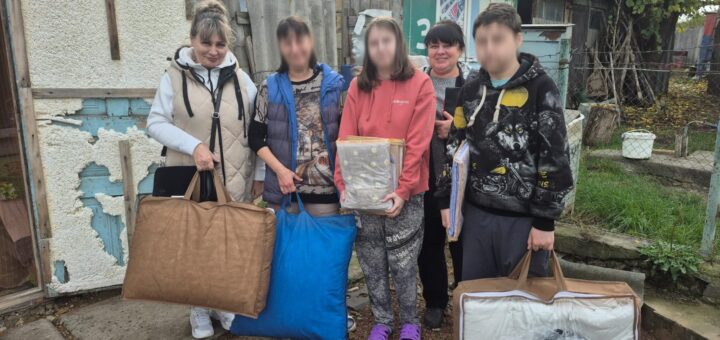 Люди біля будинку передають родині подушки, ковдри та речі домашнього вжитку як допомогу.